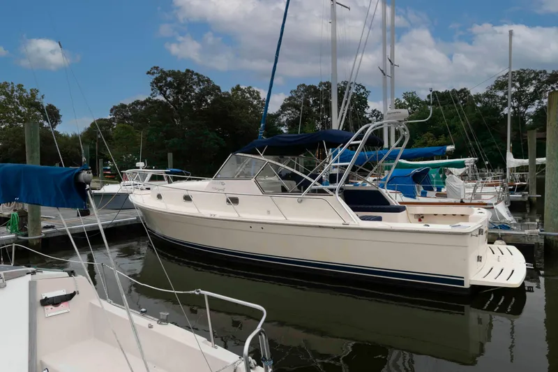 Slide: The Image of 2004 Mainship 34 Pilot Rum Runner II docked at marina under blue sky. - 3
