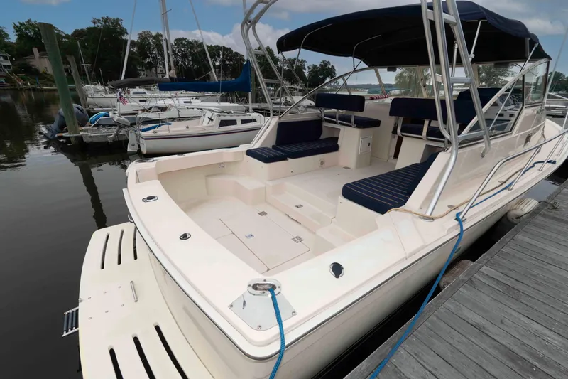 Slide: The Image of 2004 Mainship 34 Pilot Rum Runner II docked, featuring spacious seating and sleek design. - 4