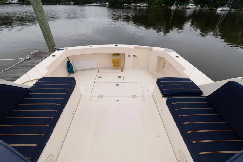 Slide: The Image of 2004 Mainship 34 Pilot Rum Runner II boat interior with blue-striped seating by the water. - 5