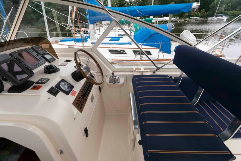 Slide: The Image of 2004 Mainship 34 Pilot Rum Runner II helm with navigation instruments and blue-striped seating. - 7