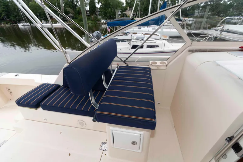 Slide: The Image of 2004 Mainship 34 Pilot Rum Runner II boat with blue-striped seating on deck. - 8