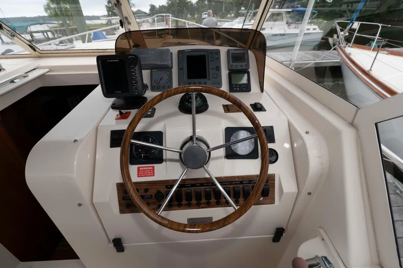 Slide: The Image of 2004 Mainship 34 Pilot Rum Runner II helm with steering wheel and navigation instruments. - 9
