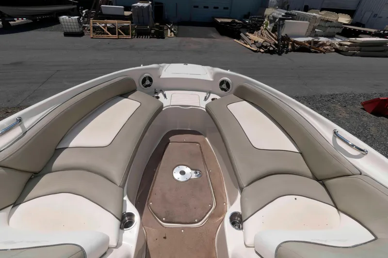 Slide: The Image of 2006 Sea Ray 240 Sundeck interior with beige seating and spacious layout. - 10