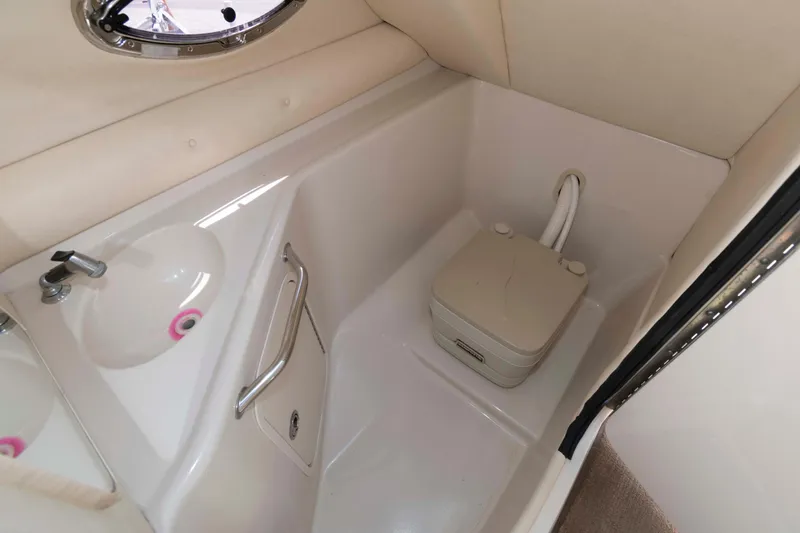 Slide: The Image of 2006 Sea Ray 240 Sundeck interior with compact marine toilet and sink. - 12
