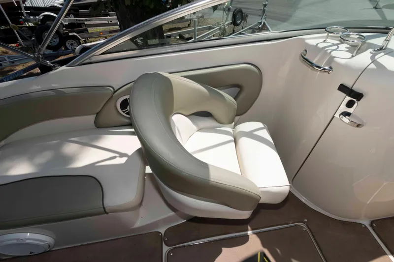 Slide: The Image of 2006 Sea Ray 240 Sundeck interior with beige seating and cup holders. - 7
