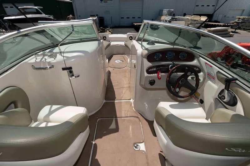Slide: The Image of 2006 Sea Ray 240 Sundeck interior with dual seating and control panel. - 8