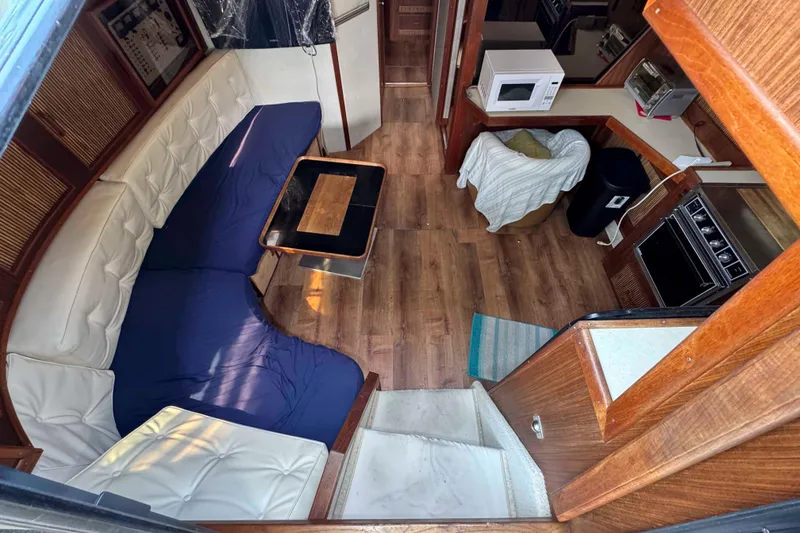 Slide: The Image of 1986 Sea Ray 390 Express Cruiser interior with wood flooring, seating, and kitchen appliances. - 10
