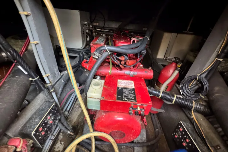 Slide: The Image of Engine compartment of 1986 Sea Ray 390 Express Cruiser with red machinery and wiring. - 22