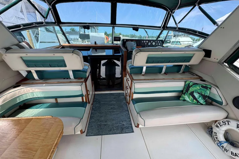 Slide: The Image of 1986 Sea Ray 390 Express Cruiser interior with teal seating and nautical decor. - 3