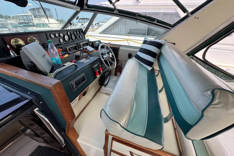Slide: The Image of 1986 Sea Ray 390 Express Cruiser cockpit with steering wheel, gauges, and seating. - 4