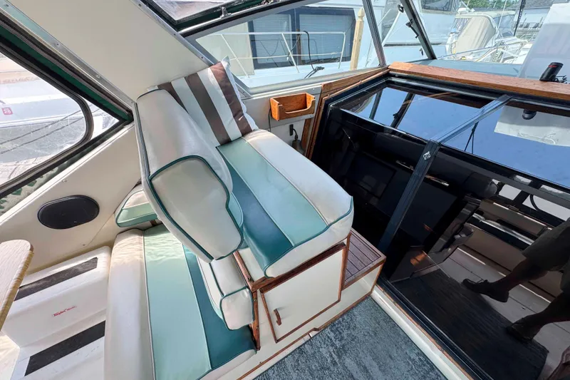 Slide: The Image of 1986 Sea Ray 390 Express Cruiser interior with striped seating and helm area. - 5