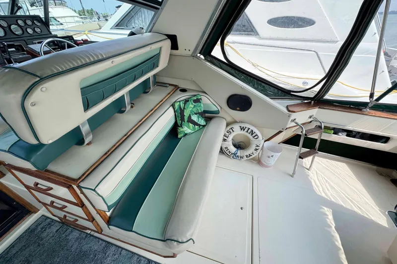 Slide: The Image of 1986 Sea Ray 390 Express Cruiser interior with green and white seating, nautical decor. - 6