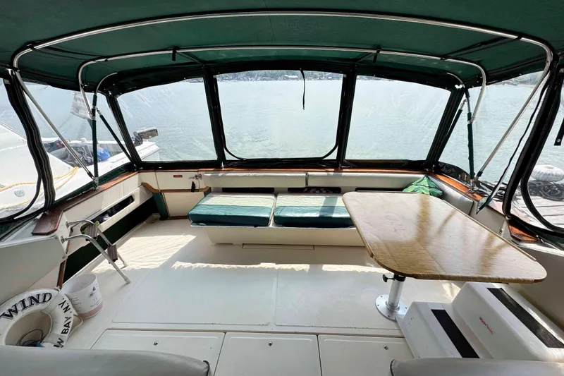 Slide: The Image of 1986 Sea Ray 390 Express Cruiser interior with seating and table, overlooking water. - 8