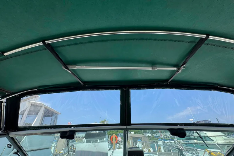 Slide: The Image of Interior view of 1986 Sea Ray 390 Express Cruiser with green canopy and marina background. - 9