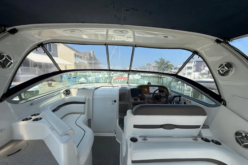 Slide: The Image of 2009 Rinker 340 Express Cruiser interior with helm, seating, and marina view. - 10