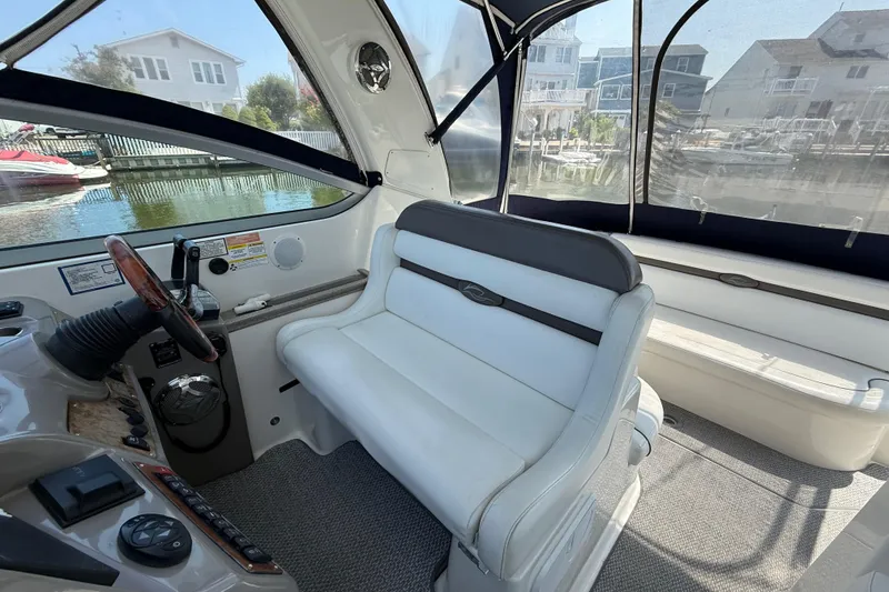 Slide: The Image of 2009 Rinker 340 Express Cruiser interior with white seating and helm controls. - 14