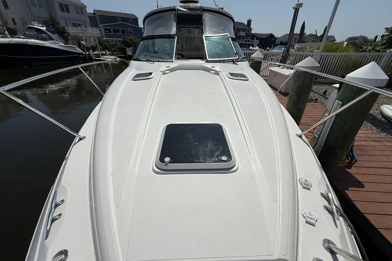 Slide: The Image of 2009 Rinker 340 Express Cruiser docked, showcasing sleek design and spacious deck. - 18