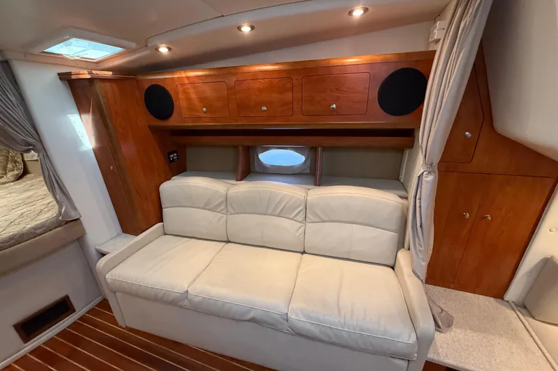 Slide: The Image of 2009 Rinker 340 Express Cruiser interior with leather sofa and wooden cabinetry. - 22