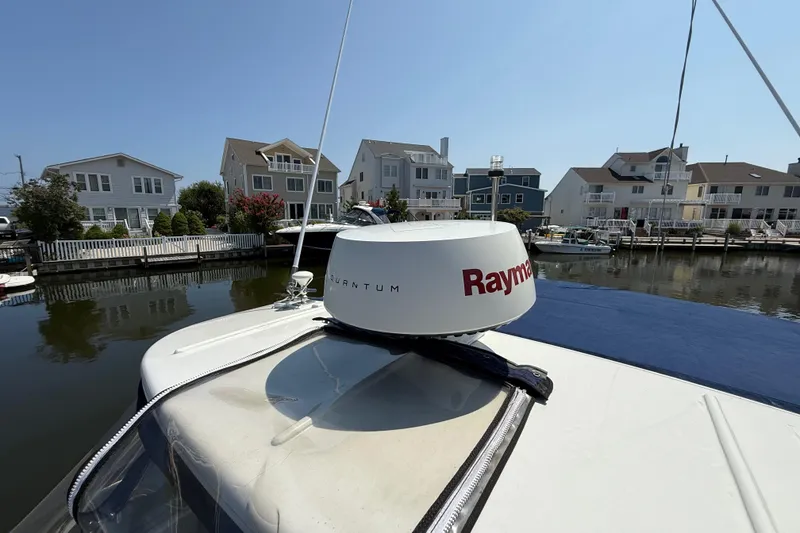 Slide: The Image of 2009 Rinker 340 Express Cruiser with Raymarine radar, docked near waterfront homes. - 33