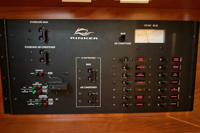 Slide: The Image of Control panel of a 2009 Rinker 340 Express Cruiser with various switches and indicators. - 35