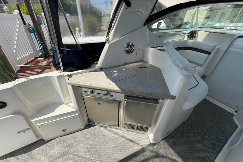 Slide: The Image of 2009 Rinker 340 Express Cruiser interior with kitchenette and seating area. - 7
