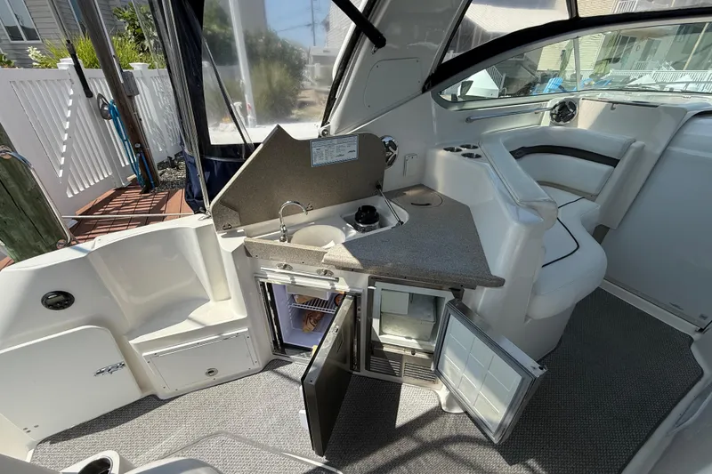 Slide: The Image of 2009 Rinker 340 Express Cruiser interior with kitchenette and seating area. - 8