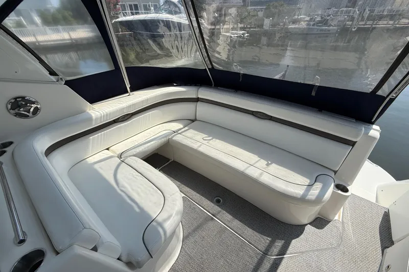 Slide: The Image of 2009 Rinker 340 Express Cruiser interior with white seating and marina view. - 9