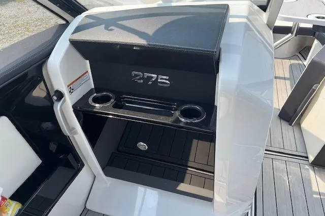 Slide: The Image of 2021 Yamaha Boats 275 SE interior with cup holders and storage compartment. - 19
