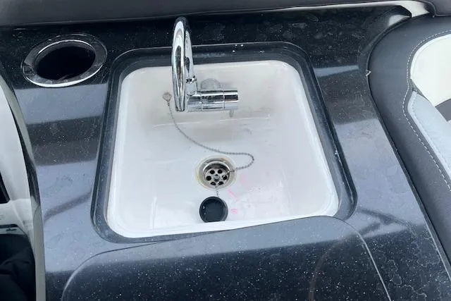 Slide: The Image of 2021 Yamaha Boats 275 SE sink with chrome faucet and cup holder. - 26