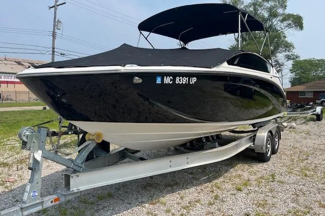 Slide: The Image of 2021 Yamaha Boats 275 SE on trailer, black hull, covered, parked outdoors. - 3