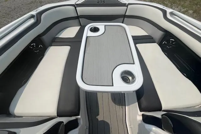 Slide: The Image of 2021 Yamaha Boats 275 SE interior with cushioned seating and table, featuring cup holders. - 38