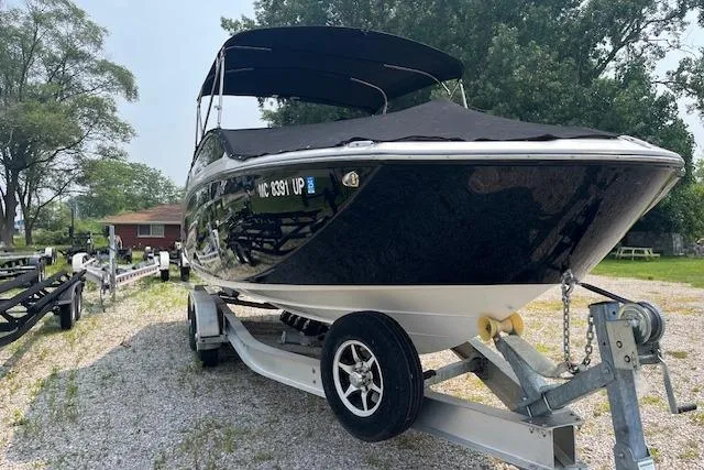 Slide: The Image of 2021 Yamaha Boats 275 SE on trailer, black hull, parked outdoors. - 5