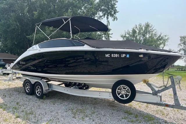 Slide: The Image of 2021 Yamaha Boats 275 SE on trailer, black and white design, parked outdoors. - 6