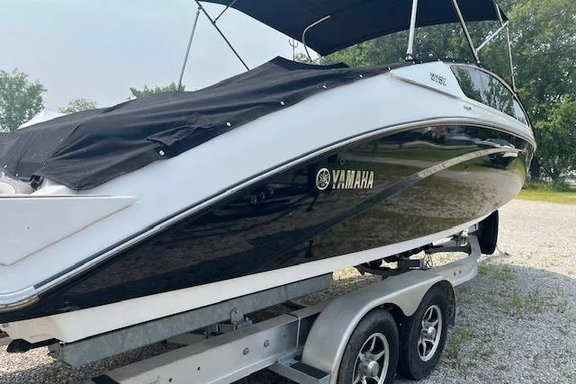 Slide: The Image of 2021 Yamaha Boats 275 SE on trailer, black and white design, covered, outdoors. - 7