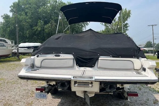 Slide: The Image of 2021 Yamaha Boats 275 SE with black cover, parked outdoors on gravel. - 8