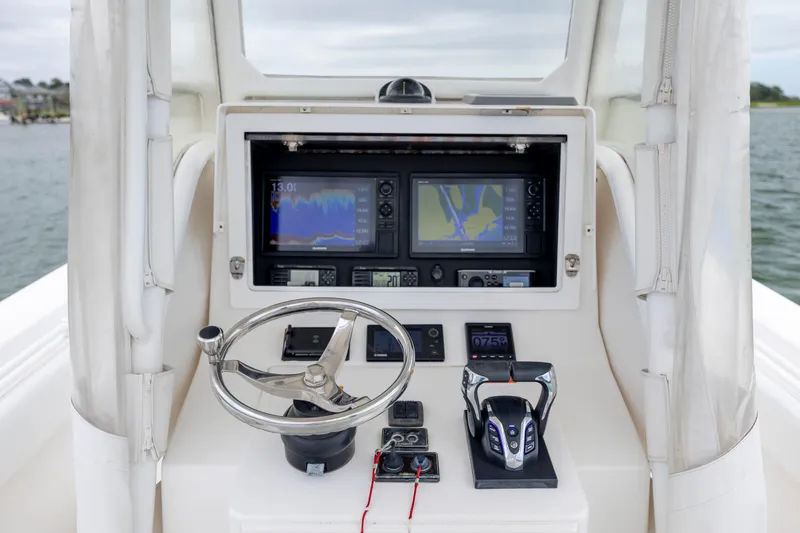 Slide: The Image of Control panel of a 2012 Contender 30 Tournament boat with navigation screens and steering wheel. - 19
