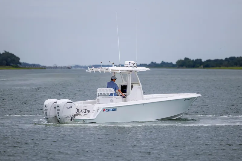Slide: The Image of 2012 Contender 30 Tournament boat cruising on calm waters with dual Yamaha engines. - 9