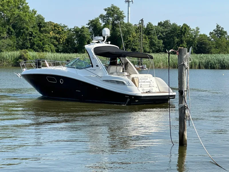Slide: The Image of 2011 Sea Ray 350 Sundancer yacht on a serene river with lush greenery. - 1