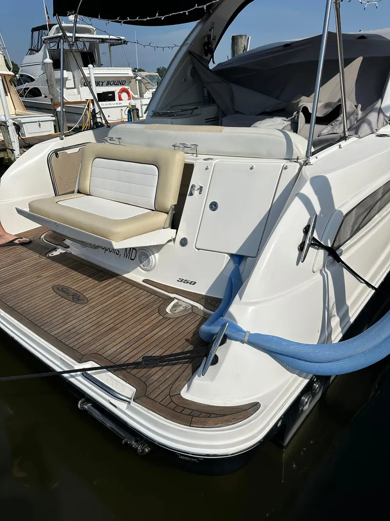 Slide: The Image of 2011 Sea Ray 350 Sundancer yacht docked, featuring a spacious rear deck and seating area. - 13