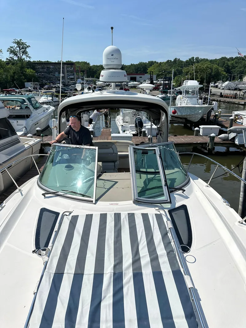 Slide: The Image of 2011 Sea Ray 350 Sundancer yacht docked at marina, featuring striped sunpad and open cockpit. - 16