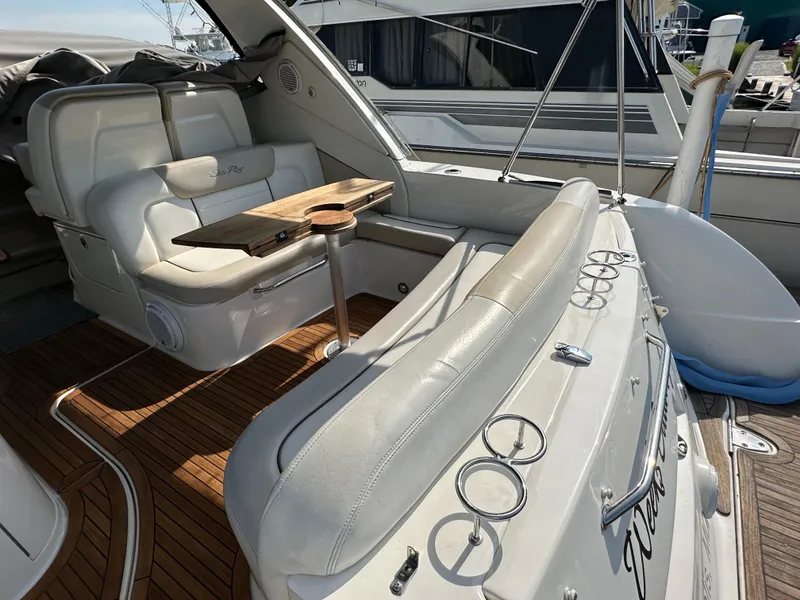 Slide: The Image of 2011 Sea Ray 350 Sundancer interior with white seating and wooden table. - 19
