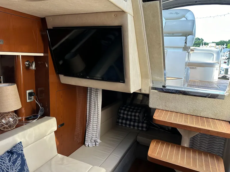 Slide: The Image of Interior of 2011 Sea Ray 350 Sundancer yacht with TV, seating, and wooden accents. - 32