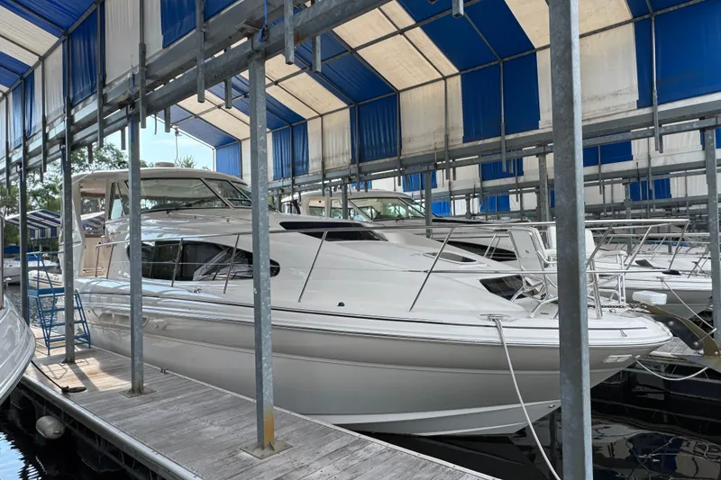 Slide: The Image of 2004 Sea Ray 390 Motor Yacht docked under blue and white canopy. - 0