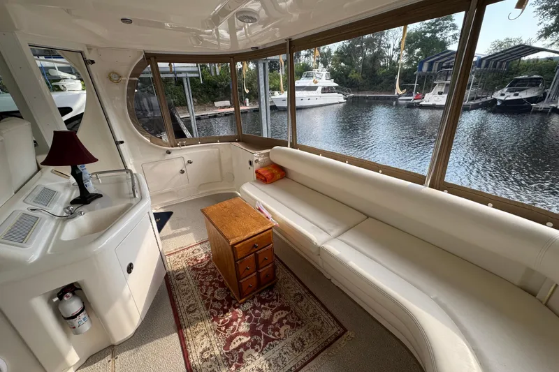 Slide: The Image of Interior of 2004 Sea Ray 390 Motor Yacht with white seating and wooden table. - 11