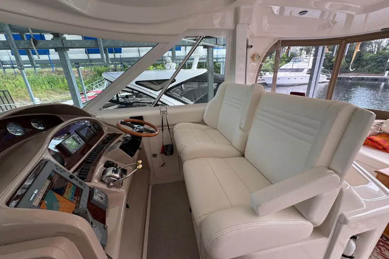 Slide: The Image of 2004 Sea Ray 390 Motor Yacht helm with plush seating and modern controls. - 14