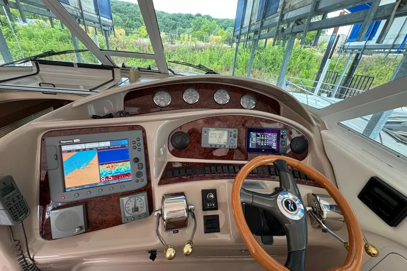Slide: The Image of 2004 Sea Ray 390 Motor Yacht helm with navigation instruments and wooden steering wheel. - 16
