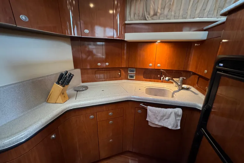 Slide: The Image of Luxurious 2004 Sea Ray 390 Motor Yacht kitchen with wood cabinetry and modern amenities. - 37