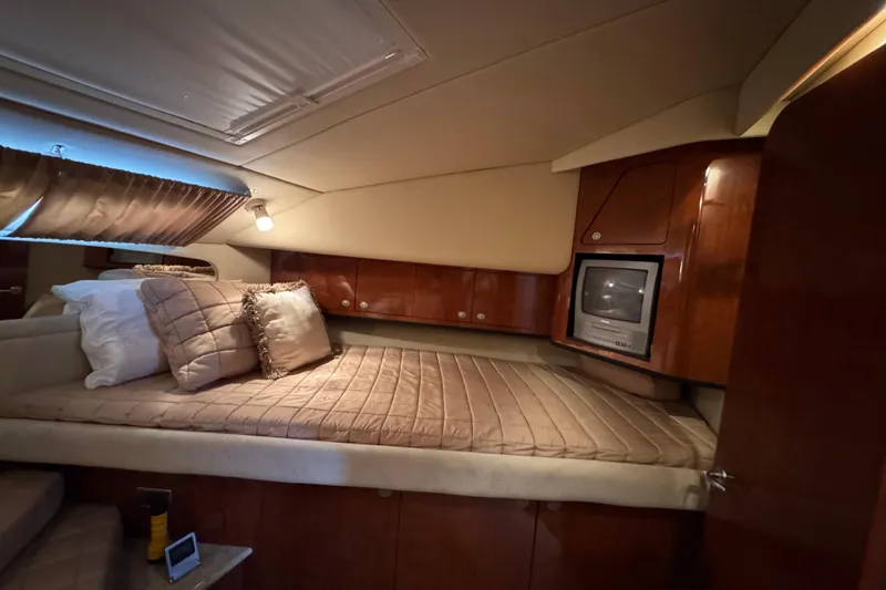 Slide: The Image of Luxurious 2004 Sea Ray 390 Motor Yacht cabin with cozy bedding and built-in TV. - 43