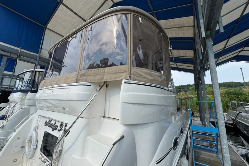 Slide: The Image of 2004 Sea Ray 390 Motor Yacht docked under a blue canopy, rear view. - 7