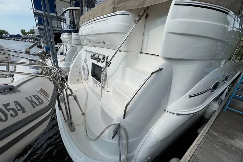 Slide: The Image of 2004 Sea Ray 390 Motor Yacht docked at marina, rear view with steps and railing. - 8